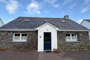 a brick house with a black roof and a blue door at Skellig Cottage - Portmagee in Lateeve