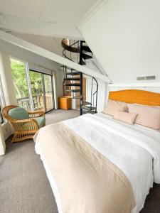 a bedroom with a large white bed and a chair at 10 Branch Bungalow Treetop in Four Seasons