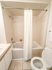 a white bathroom with a toilet and a bath tub at 10 Branch Bungalow Treetop in Four Seasons +38 photos