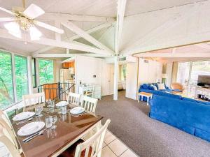 a dining room with a table and a blue couch at 10 Branch Bungalow Treetop in Four Seasons