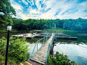 a wooden dock on a lake with people on it at 10 Branch Bungalow Treetop in Four Seasons