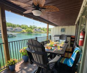 a table on a deck with a view of the water at Blueys Lakefront 2 Bed and 2 Bath Condo in Abbeyville