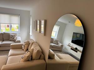 a living room with a couch and a mirror at Luxury 4BR Detached Exec Home in Cadzow