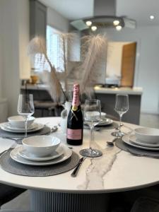 a table with glasses and a bottle of wine on it at Luxury 4BR Detached Exec Home in Cadzow