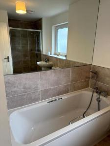 a white bath tub in a bathroom with a mirror at Luxury 4BR Detached Exec Home in Cadzow +55 photos