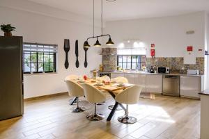 a kitchen with a table and chairs in a kitchen at Casa dos Andrades in Sesimbra