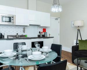 a kitchen and dining room with a glass table and chairs at GreenStar Apartments - Short Walk Away Into Dundee City Centre - 6 Individual Properties from 1 to 3 Bedrooms - Short & Long Stay Offers! in Dundee