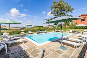 a swimming pool with umbrellas and lounge chairs and a pool at Agriturismo Rebarco in Borsecchio