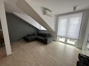 a living room with a couch and a large window at ABCD Apartments Centrum in Biała Podlaska