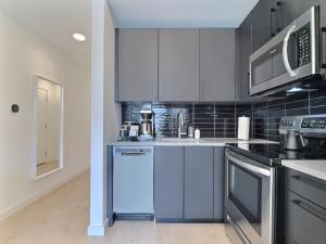 a kitchen with white cabinets and blue appliances at Modern Studio, Gym, Near UAB in Birmingham +25 photos