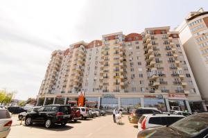 a large building with cars parked in a parking lot at ERA RENT Apartments in Chişinău