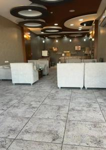 a lobby with white furniture and a large tile floor at هبوب الغيوم للشقق المخدومة - إقتصادي - Hobob Alghyoum For Serviced Apartments - Economy in Najran