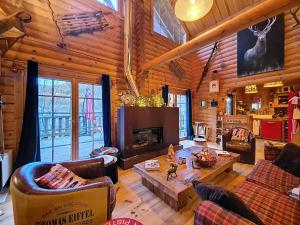 a living room with a fireplace in a log cabin at Chalet luxueux SAUNA WIFI in Roubion