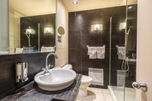 a bathroom with a sink and a toilet and a shower at Petit Hôtel - Café Krieghoff in Quebec City +49 photos