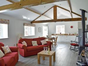a living room with a red couch and a table at The Stables - Uk13196 in Butterwick