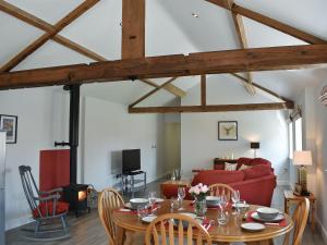 a living room with a table and a red couch at The Stables - Uk13196 in Butterwick