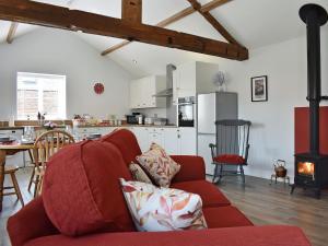a living room with a red couch and a kitchen at The Stables - Uk13196 in Butterwick