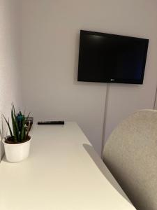 a room with a white table and a tv on a wall at Apartment Lale - Frankenwald, Waldblick & Rennsteig in Steinbach am Wald
