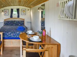 a small room with a table and a bed at Bluebell - Shepherd Hut - Uk49948 in Oswestry