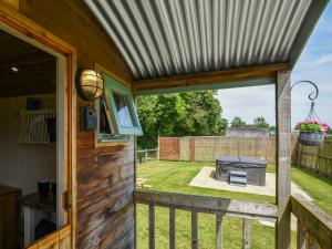 a screened in porch with a grill and a backyard at Bluebell - Shepherd Hut - Uk49948 in Oswestry