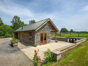 a small cabin with a patio in a field at Bluebell - Shepherd Hut - Uk49948 in Oswestry +12 photos