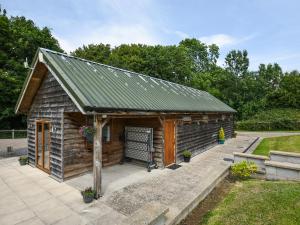 a small wooden cabin with a green roof at Bluebell - Shepherd Hut - Uk49948 in Oswestry