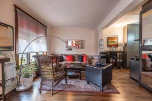 a living room with a couch and a chair at Petit Hôtel - Café Krieghoff in Quebec City