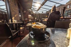 a cup of coffee sitting on a table in a restaurant at Petit Hôtel - Café Krieghoff in Quebec City