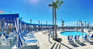 a beach area with tables, chairs and umbrellas at The Beach Club at Charleston Harbor Resort and Marina in Charleston
