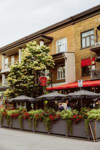 a restaurant with tables and umbrellas in front of a building at Petit Hôtel - Café Krieghoff in Quebec City