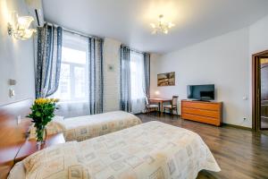 ein Hotelzimmer mit 2 Betten und einem TV in der Unterkunft Park Lane Inn in Sankt Petersburg