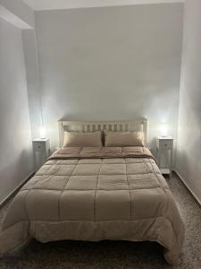 a bedroom with a large bed with two night stands at El Chalet de Lola in Playa de Miramar
