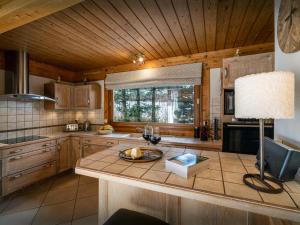 a kitchen with wooden cabinets and a table with a lamp at Chalet J'Elage - OVO Network in Saint-Jean-de-Sixt