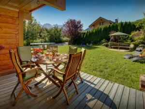 a wooden deck with a table and chairs on it at Chalet J'Elage - OVO Network in Saint-Jean-de-Sixt