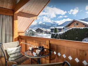a balcony with a table and a view of the mountains at Chalet J'Elage - OVO Network in Saint-Jean-de-Sixt