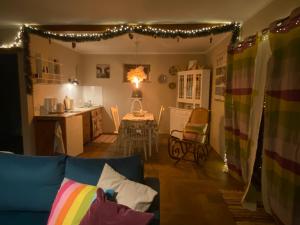 a living room with a couch and a kitchen with lights at Retro stodoła Siedlisko Klocówka Roztocze Całoroczna agroturystyka in Majdan Wielki