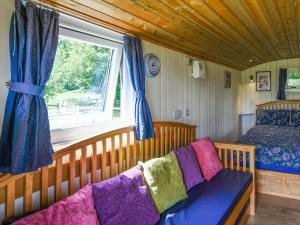 a bedroom with a couch and a window and a bed at Bluebell - Shepherd Hut - Uk49948 in Oswestry