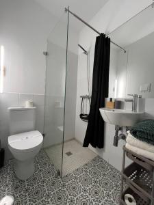 a bathroom with a shower and a toilet and a sink at Cool Guest House in Elvas