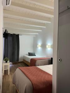 a hotel room with two beds and a ceiling at Cool Guest House in Elvas