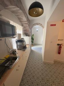 a kitchen with a sink and a tv in a room at Cool Guest House in Elvas