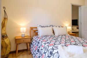 a bedroom with a bed and a table with a lamp at Casa dos Andrades in Sesimbra