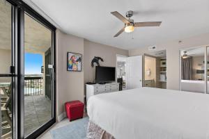 a bedroom with a bed and a tv and a balcony at SunDestin Resort Unit 1018 in Destin