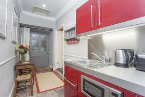 a kitchen with red cabinets and a sink at 1 Bed in Bath oc-bhr34 in Bath