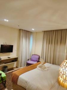 a hotel room with a bed and a purple chair at Nubian Hotel in Cairo