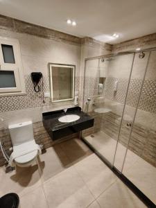 a bathroom with a toilet and a sink and a shower at Nubian Hotel in Cairo