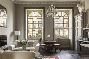 a living room with a chandelier and two windows at 1 Bed in Bath oc-bhr33 in Bath