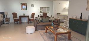 a living room with a couch and a table at Agape Apartments in Somerset West