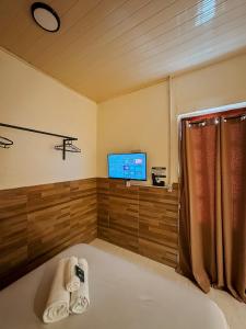 a bathroom with a tub and a tv in a room at Espaços Cardoso, AURORA - luz e leveza in Igrejinha