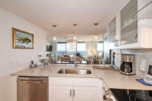 a kitchen with a sink and a living room at One Seagrove Place 0205 in Santa Rosa Beach