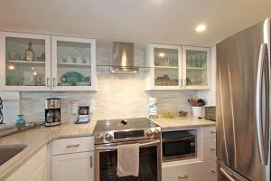 a kitchen with white cabinets and a stainless steel refrigerator at One Seagrove Place 0205 in Santa Rosa Beach